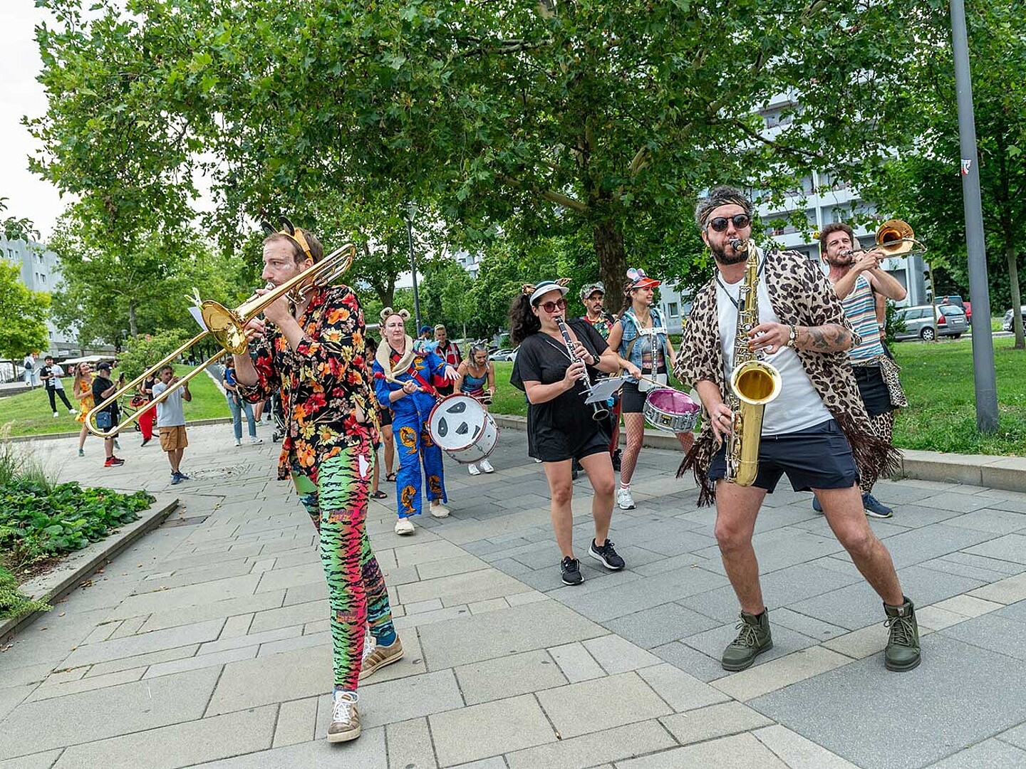 Eine Blaskapelle zieht die Marzahner Promenade entlang. 