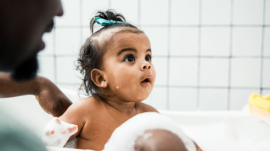 Kleinkind sitzt in einer Badewanne