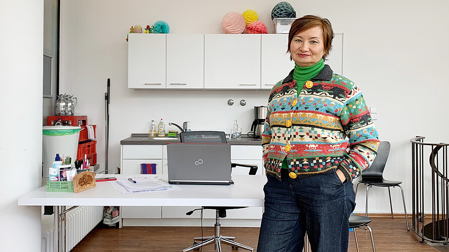 Alma Evert steht in ihrem Büro vorm Tisch