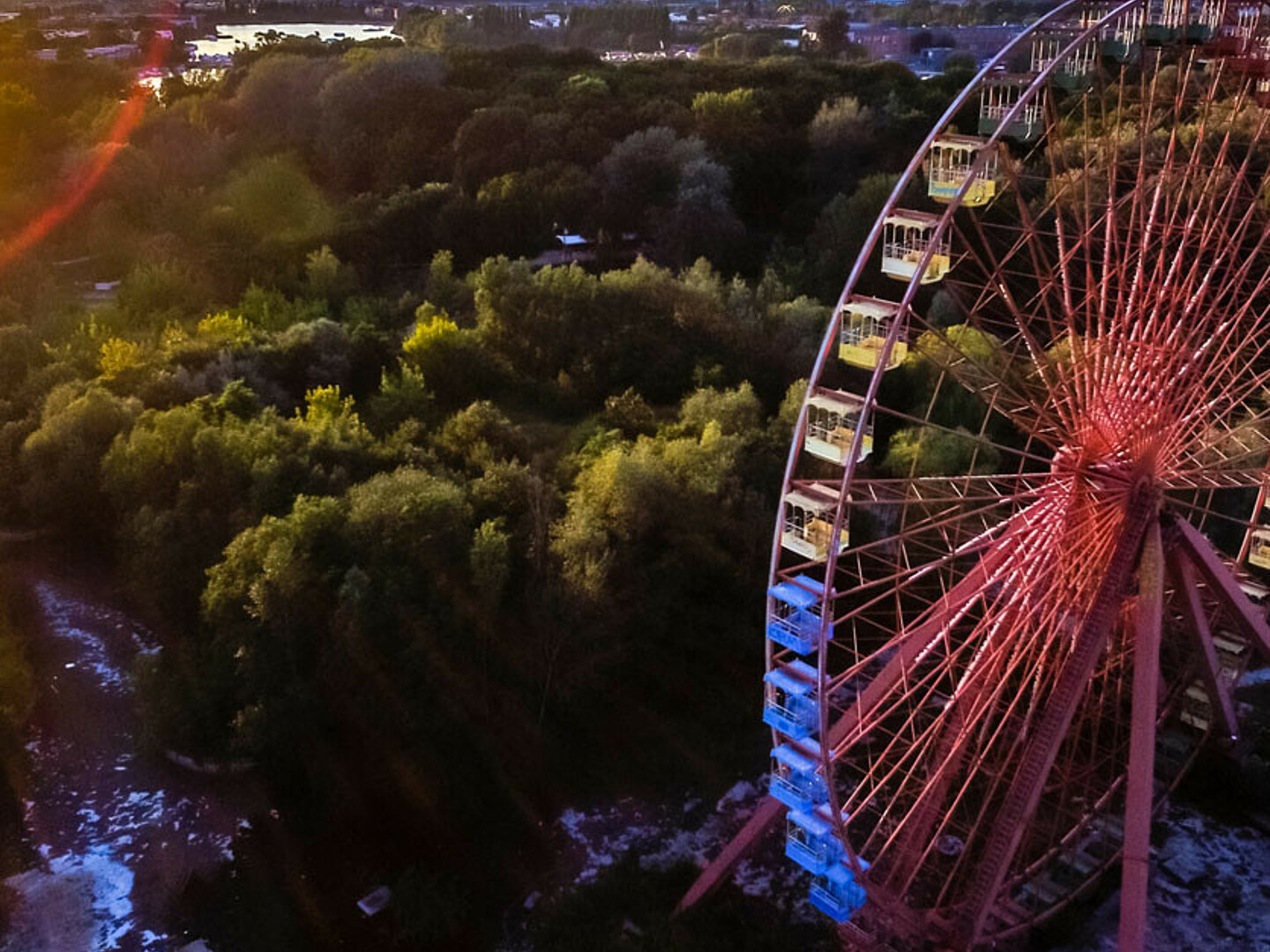 Luftbild von einem Riesenrad mit Wald im Hintergrund.