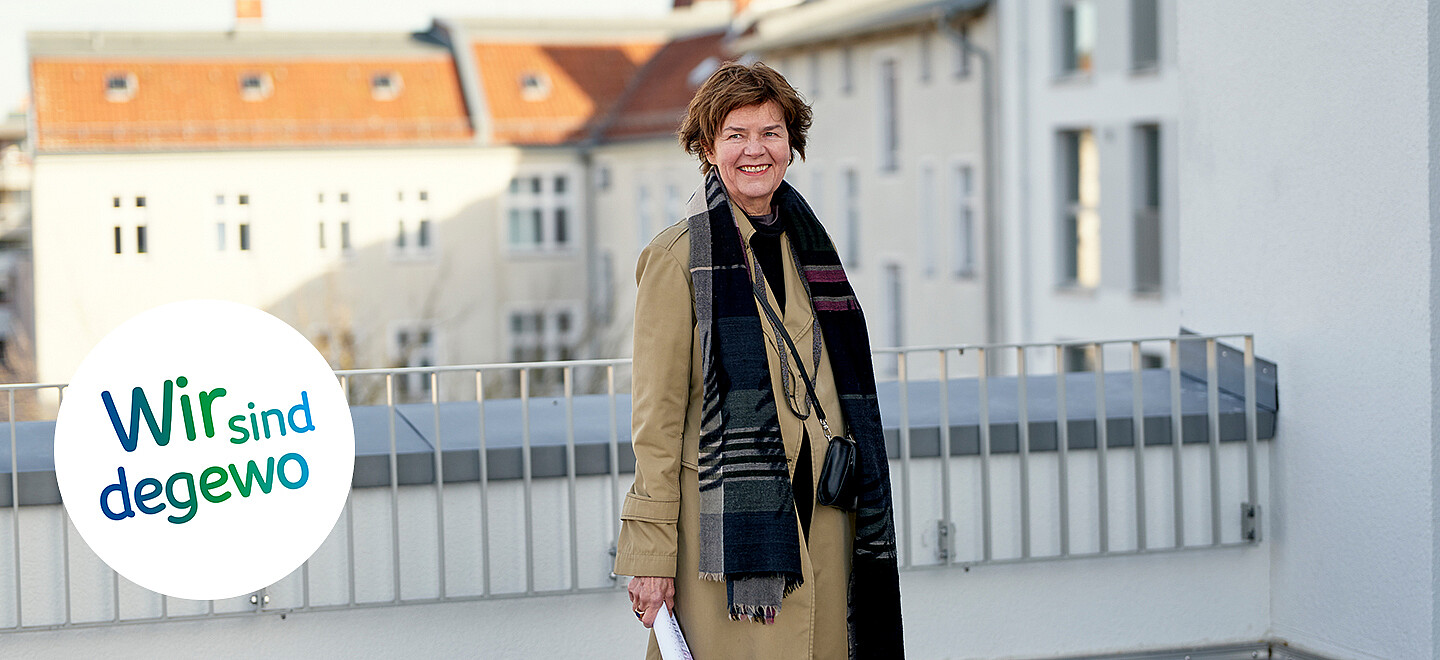 Die Architektin Anne Lampen steht auf einer Dachterrasse eines Neubaus. Im Hintergrund ist eine Kirche zu erkennen. 