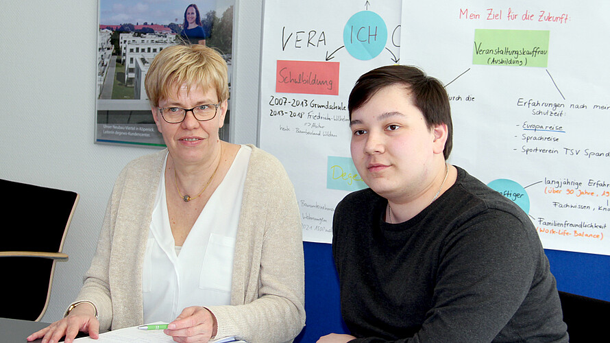 Eine Frau und ein junger Mann sitzen am Tisch.