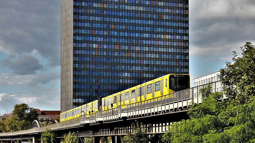 Die Berliner U-Bahn fährt am Postbank-Hochhaus vorbei.